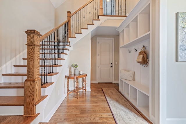 mudroom with a towering ceiling and light wood-type flooring