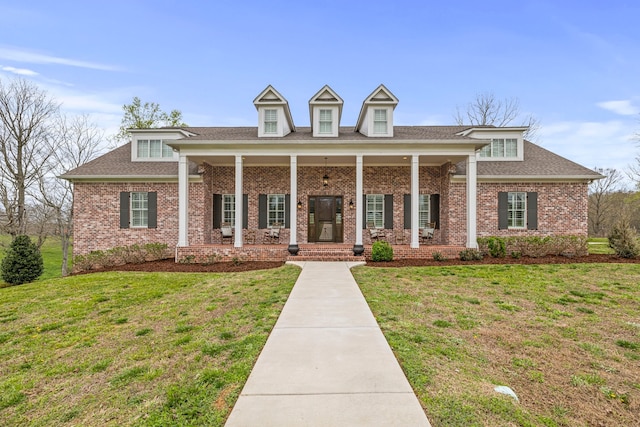 cape cod home featuring covered porch and a front lawn