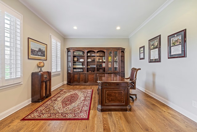 office with light hardwood / wood-style flooring, ornamental molding, and a healthy amount of sunlight