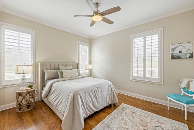 bedroom featuring multiple windows, dark wood-type flooring, and ceiling fan