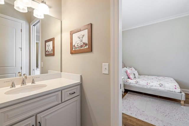 bathroom featuring crown molding, hardwood / wood-style floors, and vanity