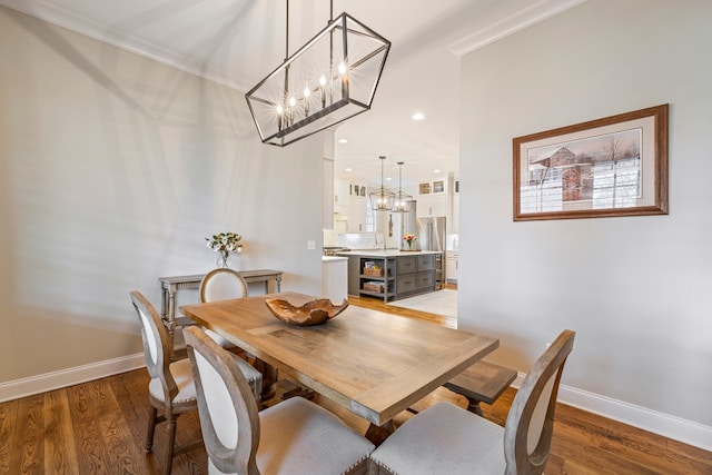 dining area featuring dark hardwood / wood-style flooring, a notable chandelier, and ornamental molding