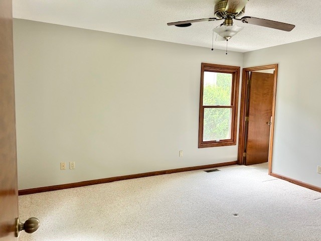 spare room featuring carpet, ceiling fan, and a textured ceiling