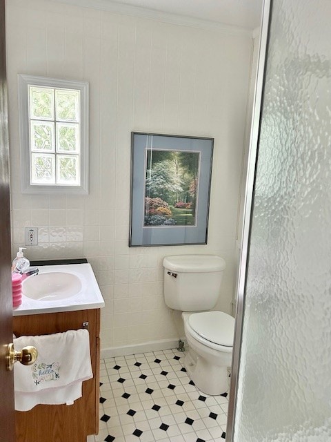 bathroom featuring tile flooring, tile walls, toilet, and vanity