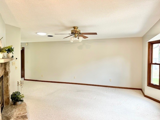 empty room featuring a textured ceiling, ceiling fan, and carpet floors