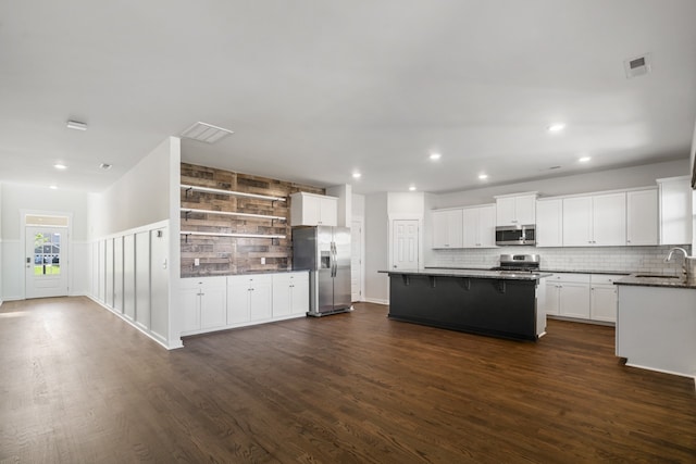 kitchen with a kitchen breakfast bar, stainless steel appliances, a center island, dark hardwood / wood-style floors, and sink