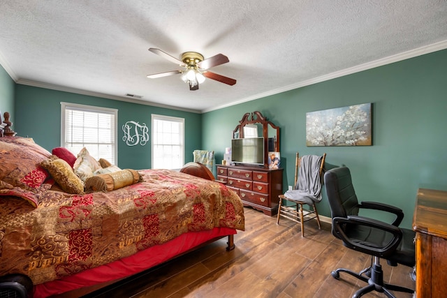 bedroom with ceiling fan, crown molding, dark wood-type flooring, and a textured ceiling