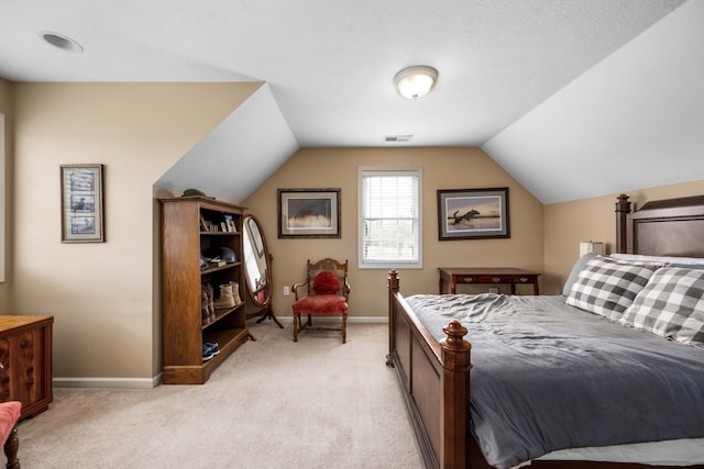 bedroom featuring lofted ceiling, a textured ceiling, and light carpet