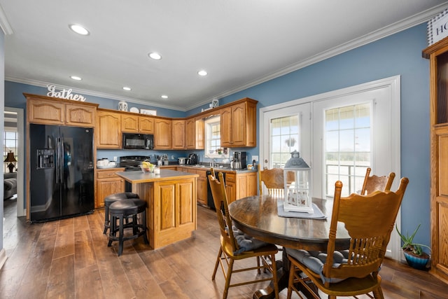 dining room featuring dark hardwood / wood-style floors, ornamental molding, plenty of natural light, and sink