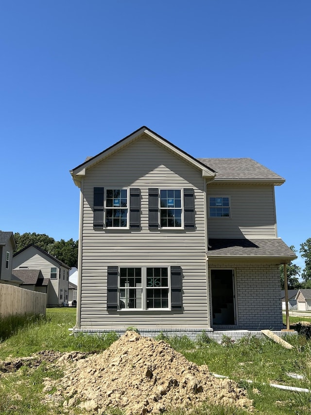 rear view of house featuring a yard