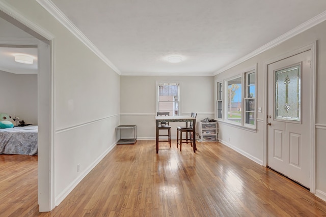 office area with light hardwood / wood-style floors and crown molding