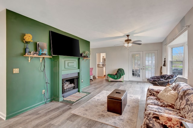 living room with french doors, light hardwood / wood-style floors, and ceiling fan