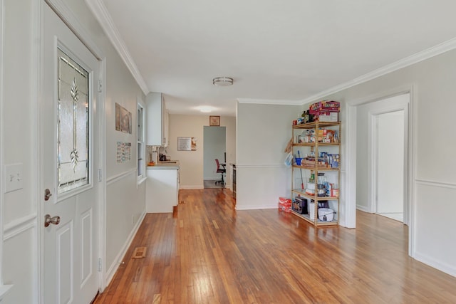 entrance foyer featuring ornamental molding and light wood-type flooring