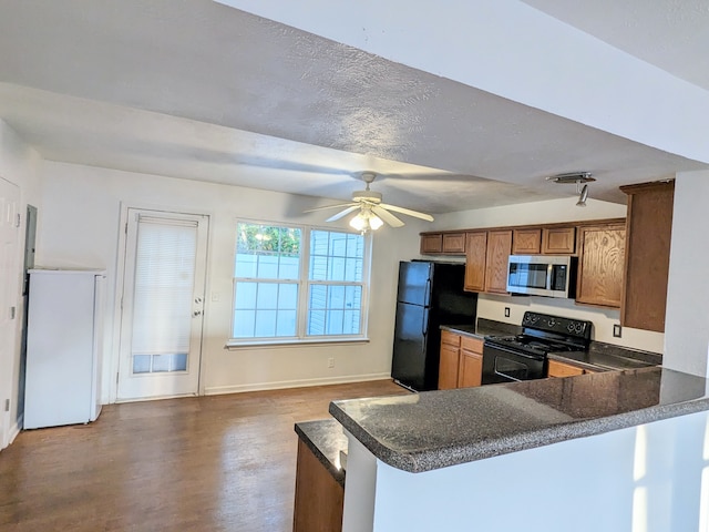 kitchen featuring kitchen peninsula, dark hardwood / wood-style floors, ceiling fan, and black appliances