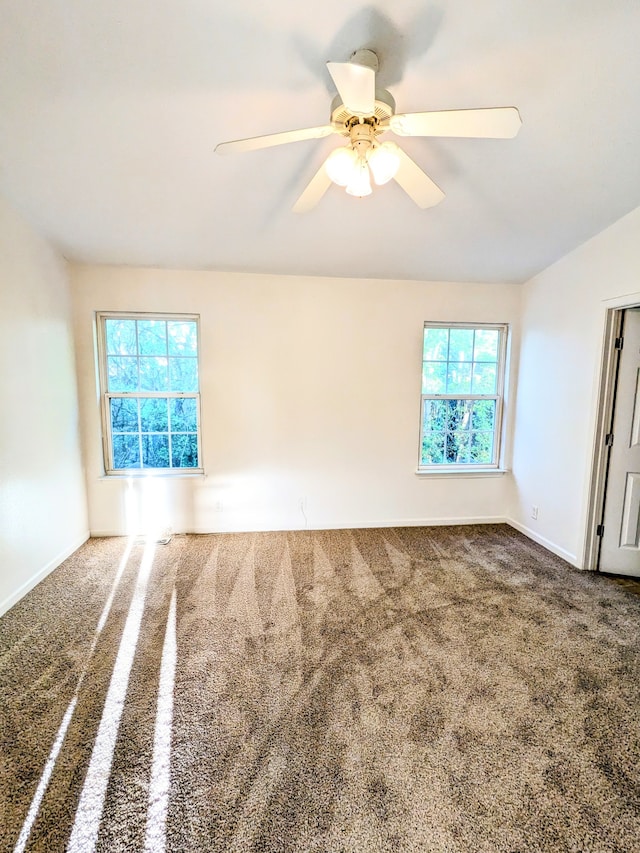 carpeted empty room with plenty of natural light and ceiling fan