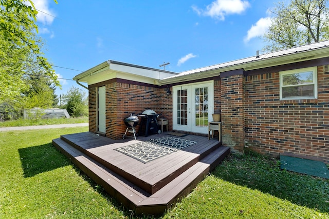 deck featuring french doors, a yard, and grilling area