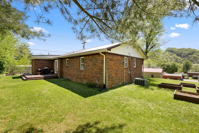 view of home's exterior with a wooden deck, central AC unit, and a lawn