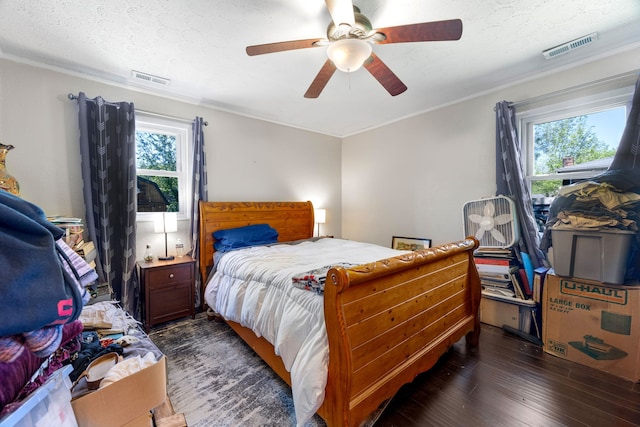 bedroom featuring ornamental molding, dark hardwood / wood-style flooring, ceiling fan, and a textured ceiling