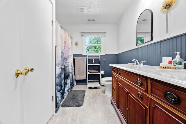 bathroom featuring a textured ceiling, vanity, and toilet