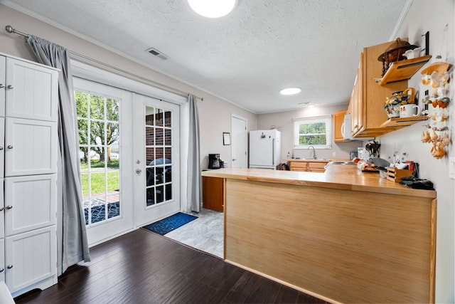 kitchen featuring white appliances, french doors, dark hardwood / wood-style floors, butcher block counters, and a textured ceiling