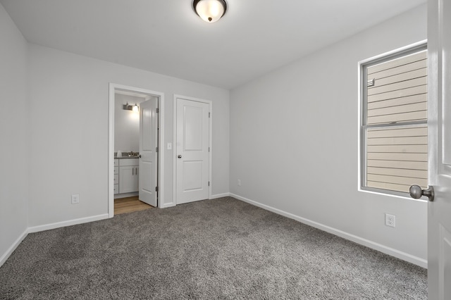 unfurnished bedroom featuring a closet, connected bathroom, and carpet flooring