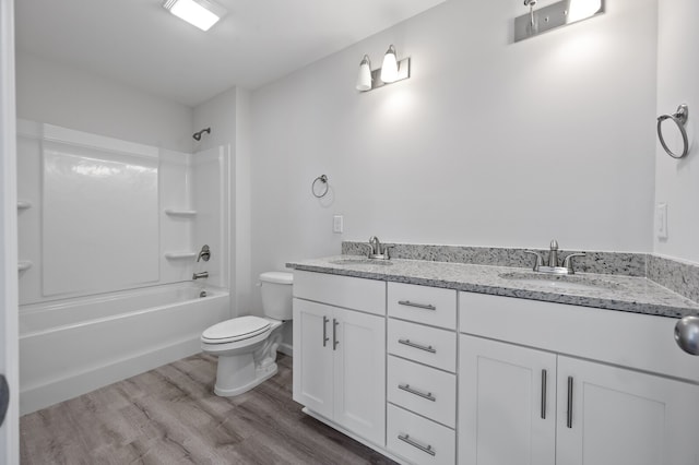 full bathroom featuring vanity, wood-type flooring, washtub / shower combination, and toilet