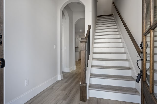 staircase featuring wood-type flooring