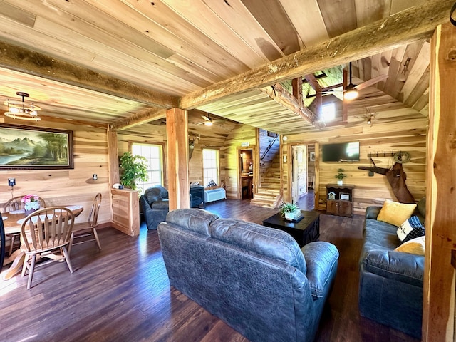 living room with ceiling fan, lofted ceiling with beams, dark wood-type flooring, wooden ceiling, and wood walls