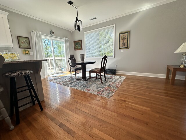 dining space with crown molding and dark wood-type flooring