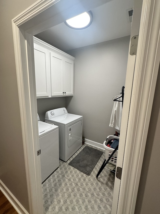 laundry area with washer and clothes dryer and cabinets