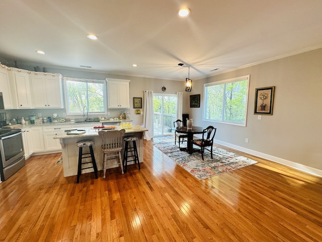 kitchen featuring a center island, white cabinetry, sink, and appliances with stainless steel finishes