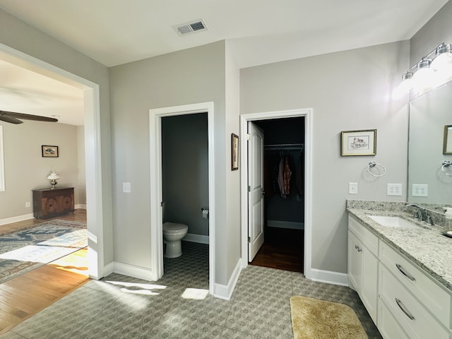 bathroom with ceiling fan, vanity, and toilet