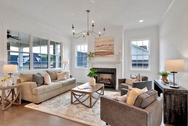 living room featuring ceiling fan with notable chandelier and wood-type flooring