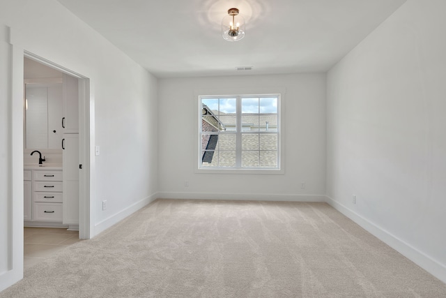 empty room with light colored carpet and sink