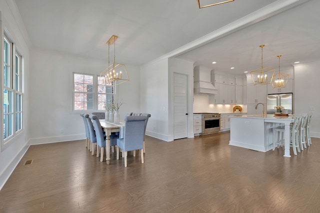 dining space featuring dark hardwood / wood-style flooring, crown molding, sink, and a notable chandelier