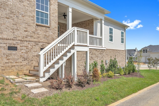 rear view of property featuring ceiling fan and a lawn