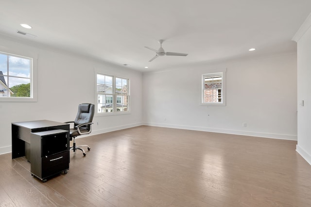 office space featuring wood-type flooring, ceiling fan, a healthy amount of sunlight, and crown molding