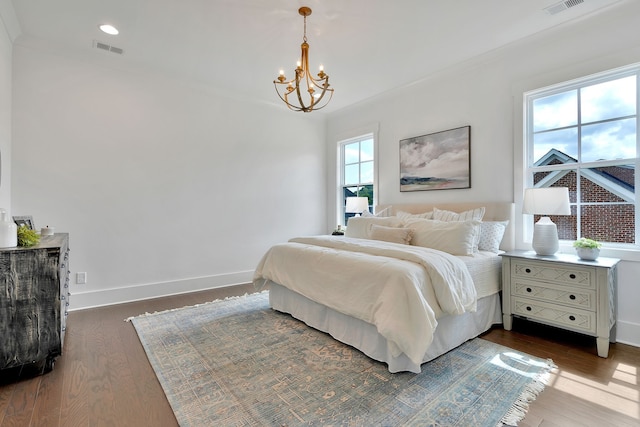 bedroom with ornamental molding, an inviting chandelier, and dark wood-type flooring