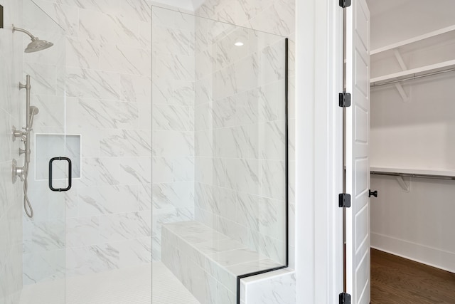 bathroom featuring wood-type flooring and an enclosed shower