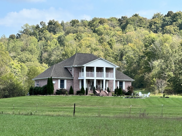 neoclassical / greek revival house with a front yard and a balcony