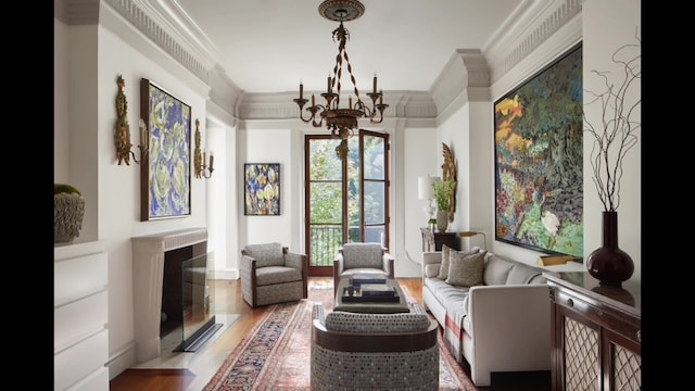 living area with wood-type flooring, a chandelier, and ornamental molding