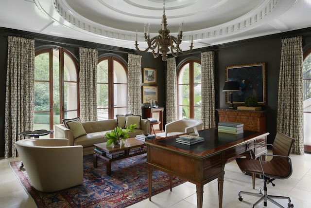 home office with a healthy amount of sunlight, a raised ceiling, light tile floors, and a chandelier