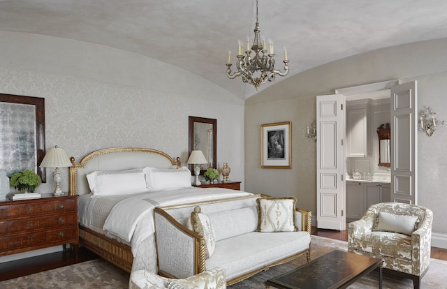 bedroom featuring ensuite bathroom, dark hardwood / wood-style flooring, vaulted ceiling, and an inviting chandelier