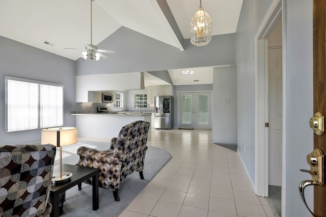 interior space with ceiling fan with notable chandelier, high vaulted ceiling, french doors, and a wealth of natural light