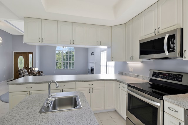 kitchen featuring light tile patterned floors, appliances with stainless steel finishes, sink, and white cabinetry