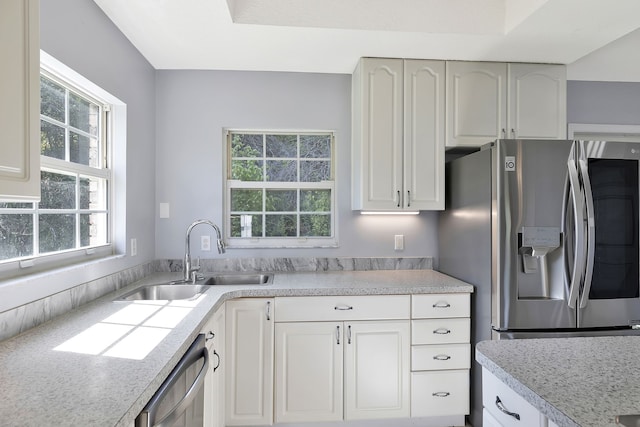 kitchen featuring appliances with stainless steel finishes, white cabinetry, sink, and a wealth of natural light