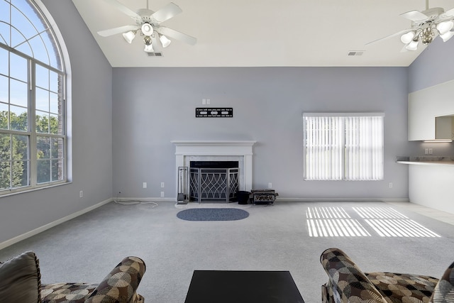 unfurnished living room featuring high vaulted ceiling, ceiling fan, and carpet floors