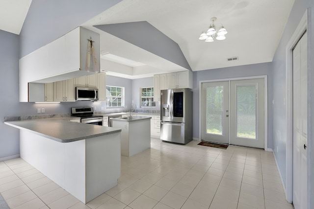 kitchen featuring stainless steel appliances, a chandelier, kitchen peninsula, and light tile patterned floors