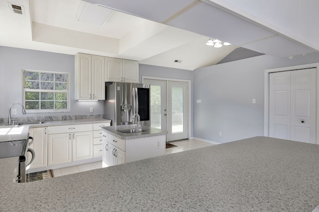 kitchen with stainless steel fridge with ice dispenser, light tile patterned floors, sink, and a healthy amount of sunlight