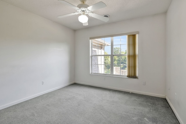 spare room with a textured ceiling, carpet flooring, and ceiling fan